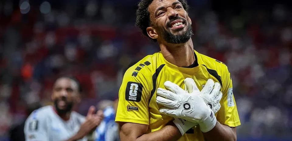 Goalkeeper celebrating with gloves raised in victory