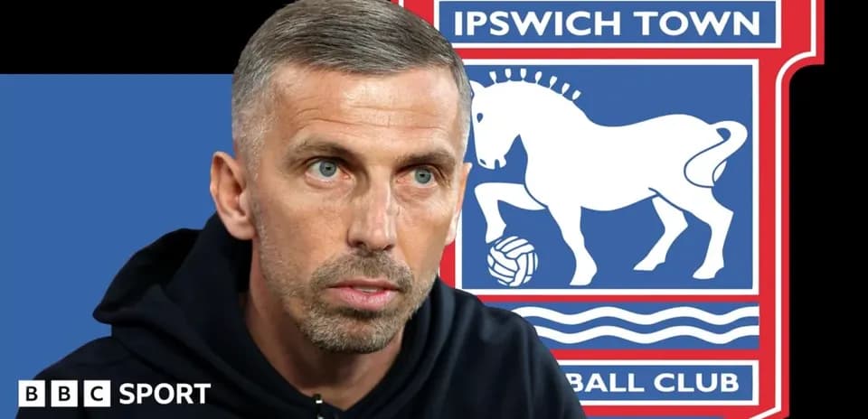 Man speaking with Ipswich Town logo in background