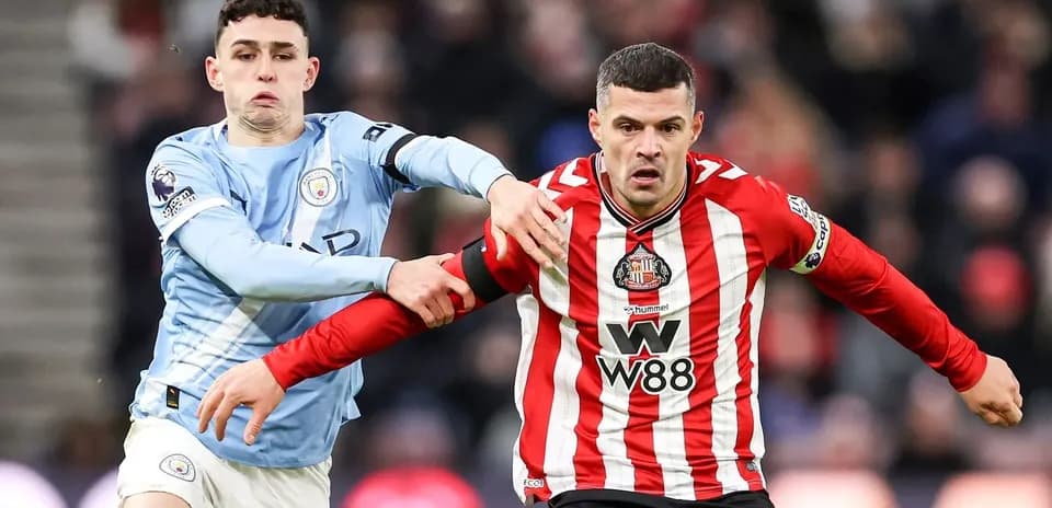 Manchester City player tackling Sunderland opponent