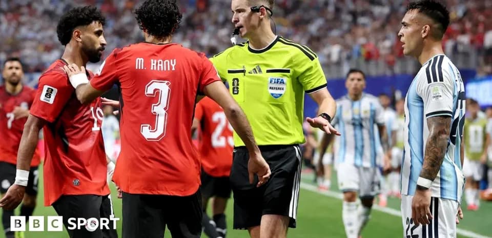 Players and referee discussing during intense match moment