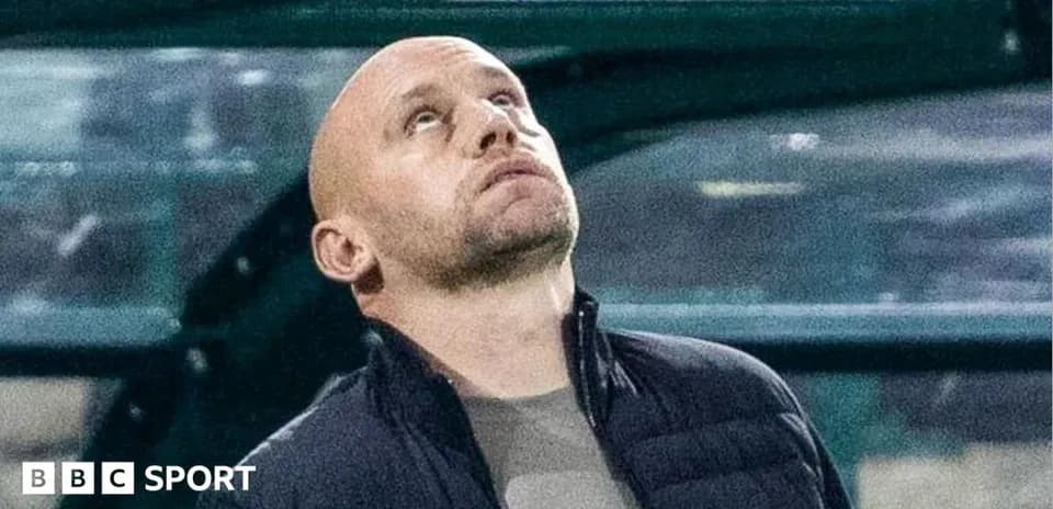 Coach looking up during match from sidelines