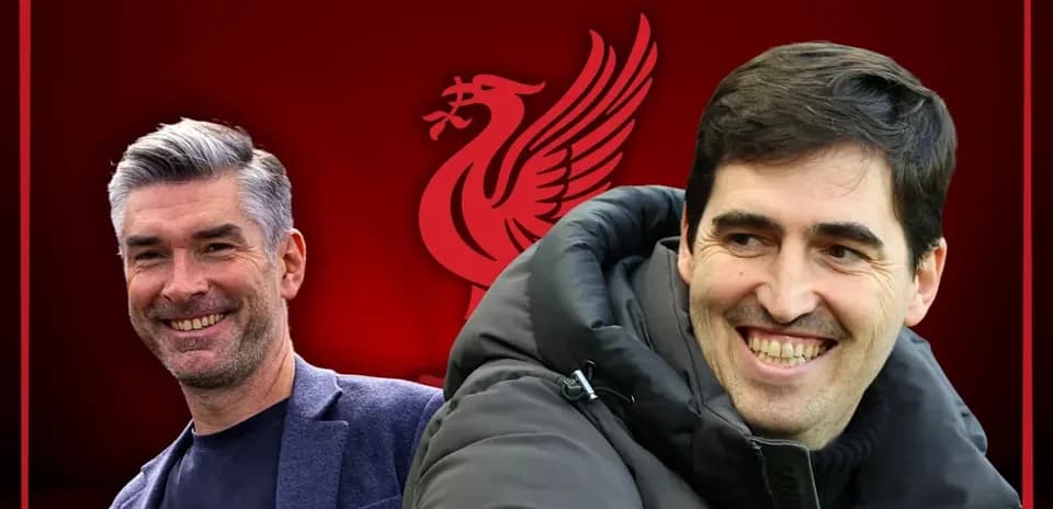 Two coaches smiling against Liverpool logo backdrop
