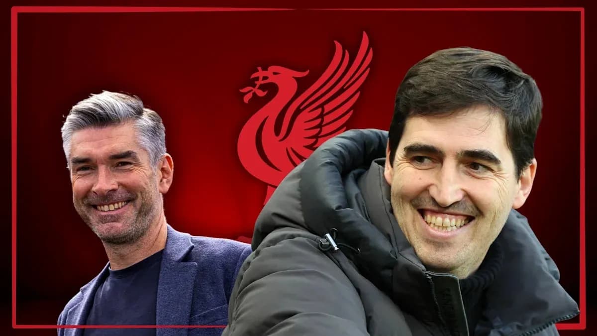 Two coaches smiling against Liverpool logo backdrop