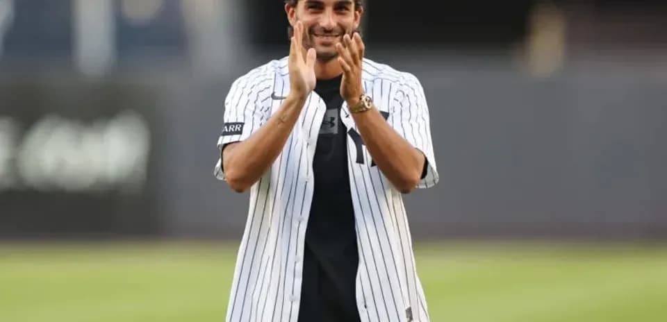 Man in Yankees jersey clapping at stadium