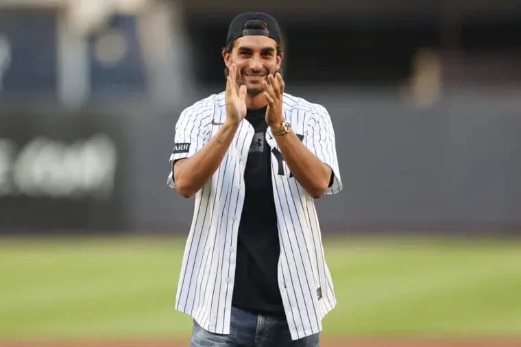 Man in Yankees jersey clapping at stadium