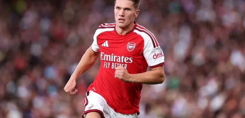 Player in Arsenal kit running on the pitch
