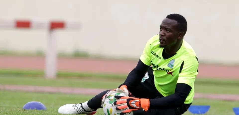 Goalkeeper training on pitch, catching a ball
