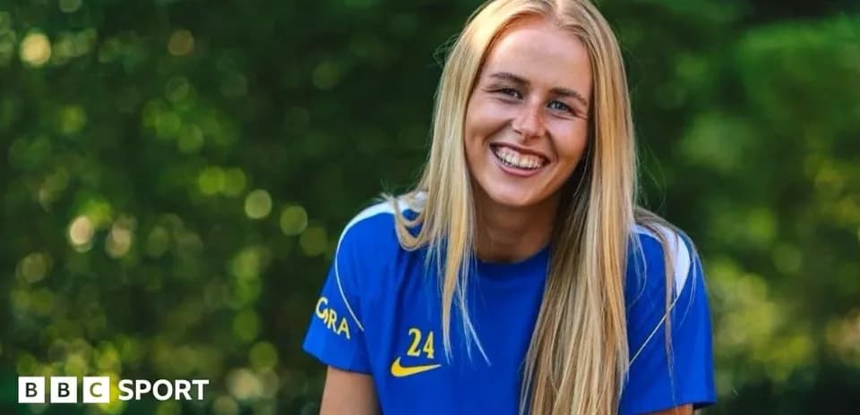 Female football player smiling in team jersey