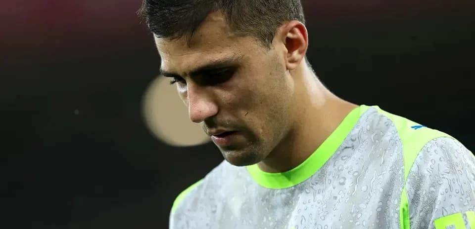 Player in training gear looking down during warm-up