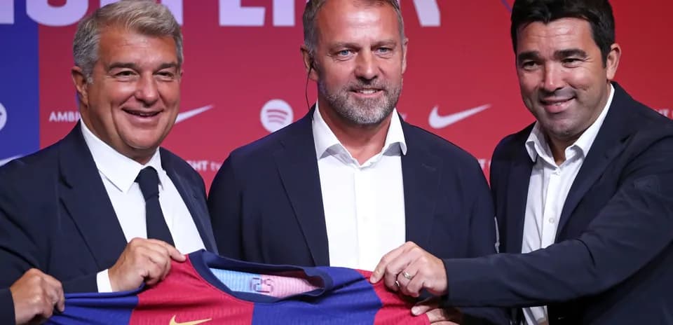 Three officials holding a Barcelona jersey at event
