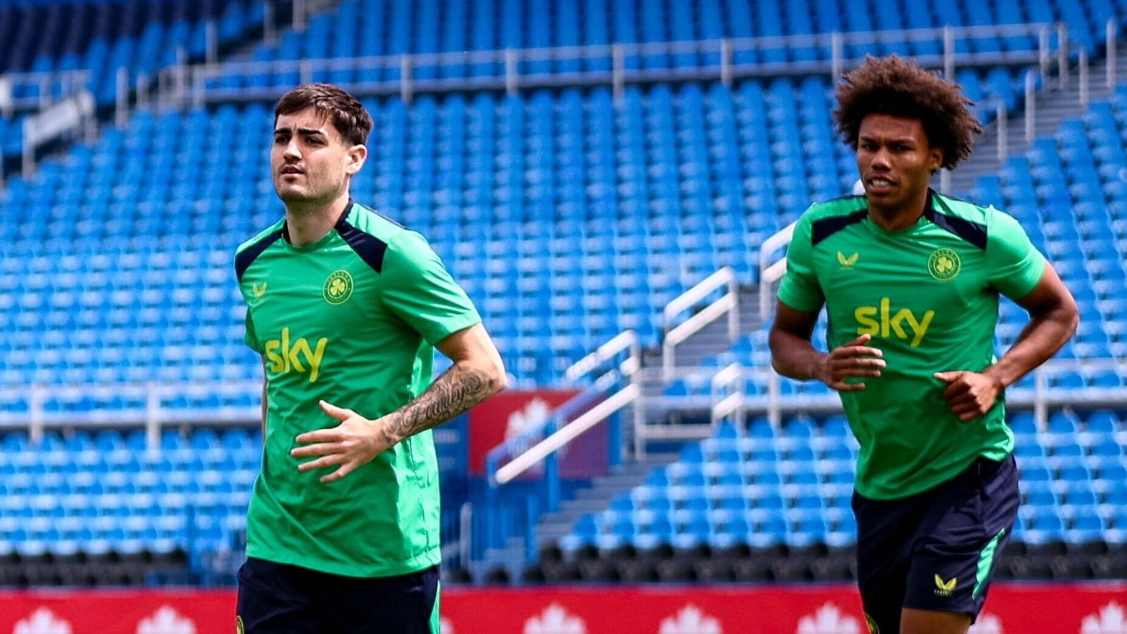 Two players jogging during training session at stadium