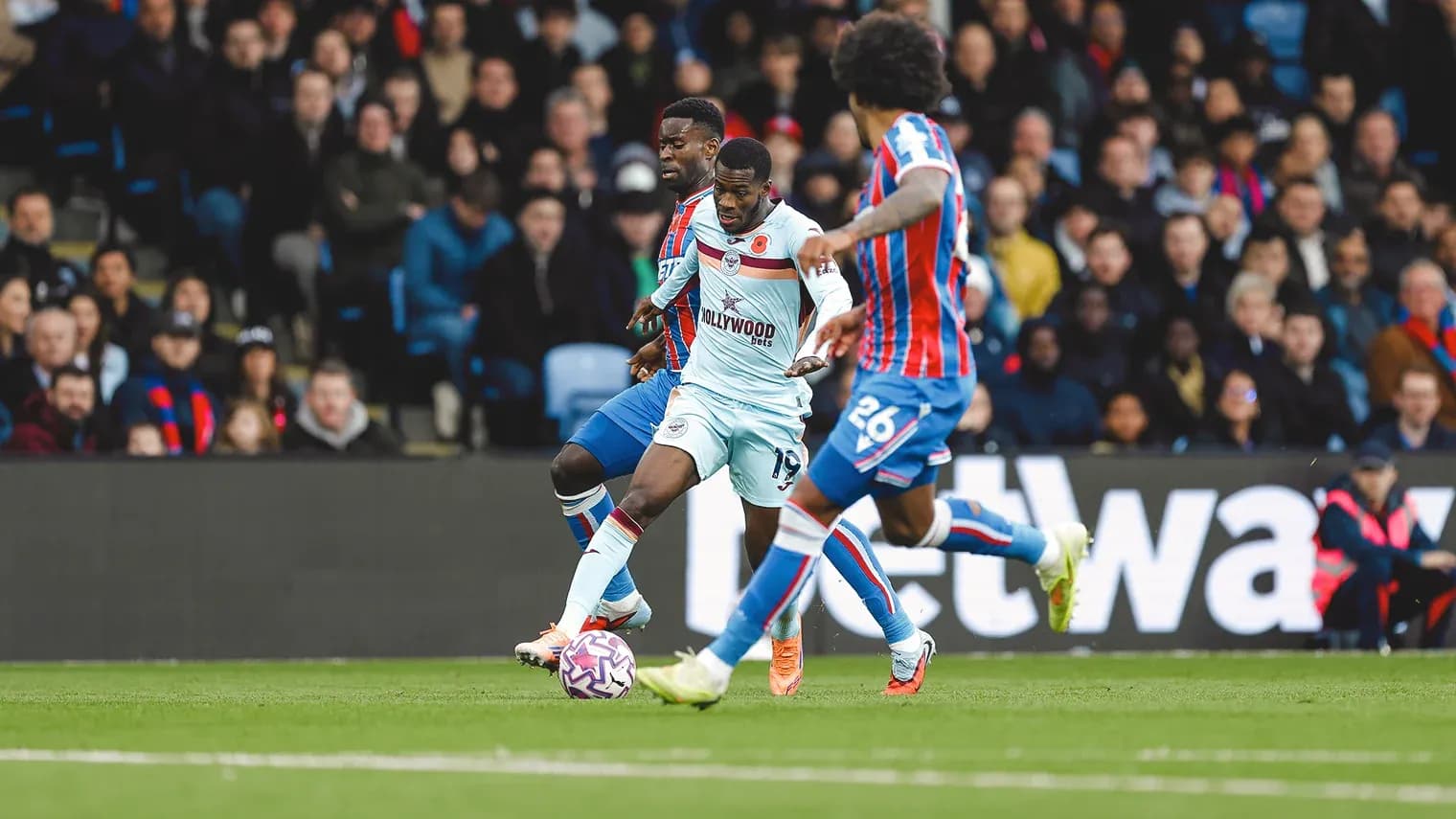 Brentford player dribbling against Crystal Palace defenders
