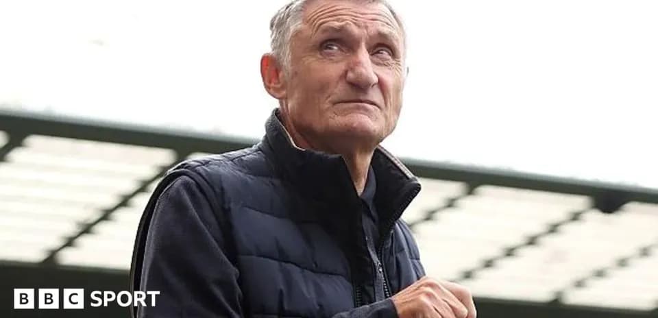 Man holding a bottle, looking upwards outdoors