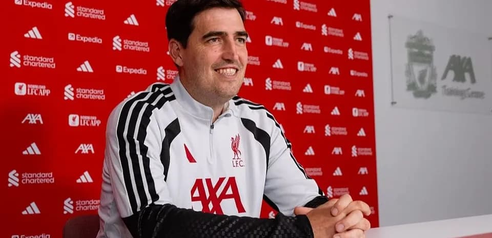 Coach sitting at press conference table at training center
