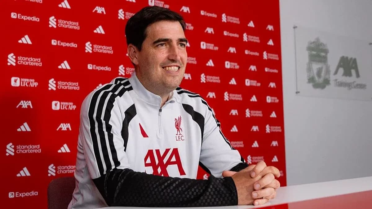 Coach sitting at press conference table at training center