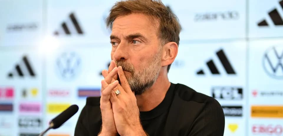 Manager speaking during press conference with logos