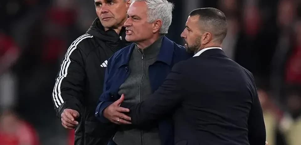 Coach being restrained by staff during match