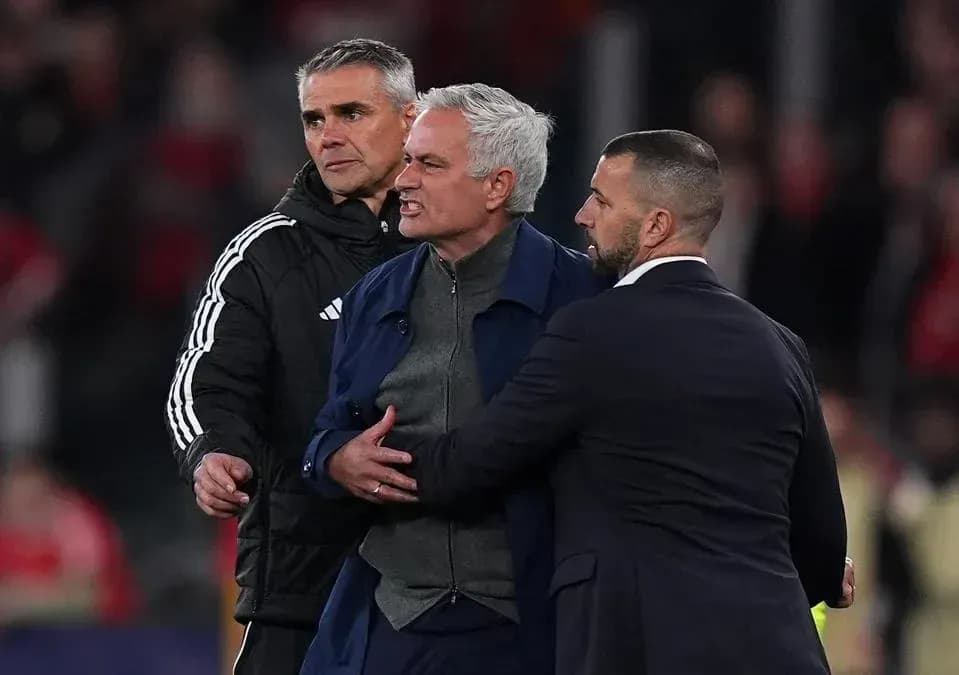 Coach being restrained by staff during match