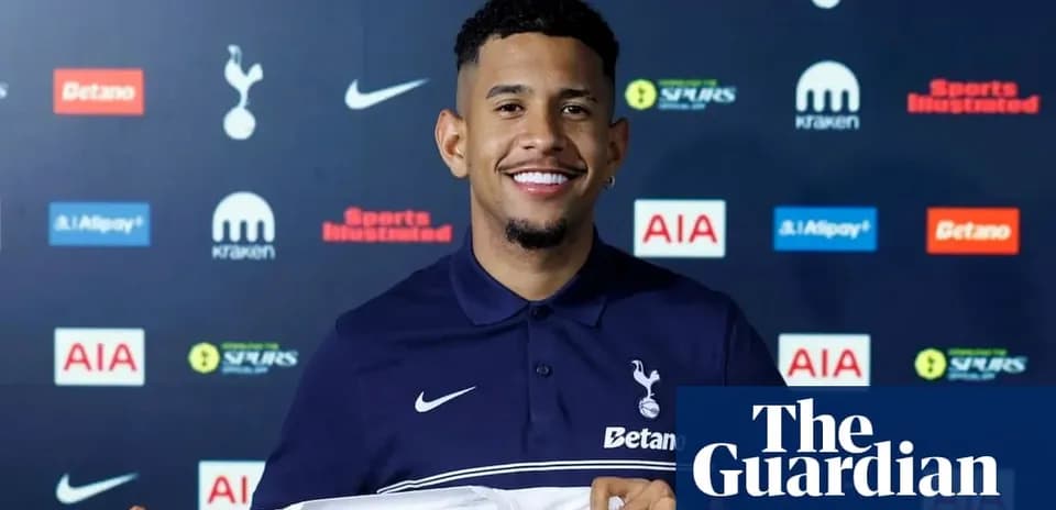 Player holding Tottenham Hotspur jersey at press conference