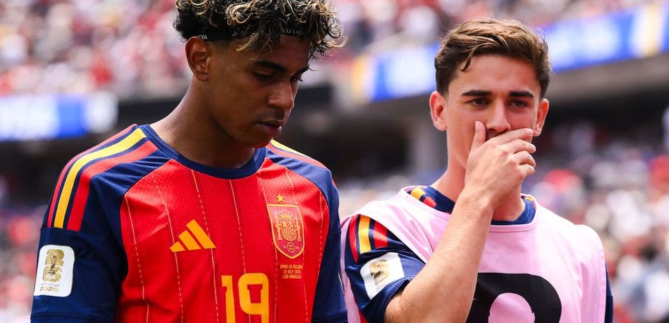 Two Spain players on sidelines during match