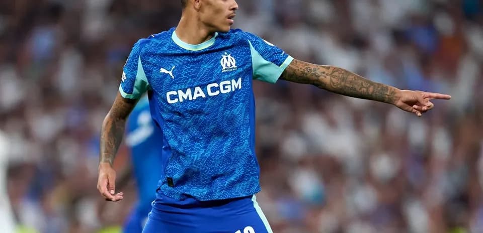 Player in Marseille kit directing teammates during match
