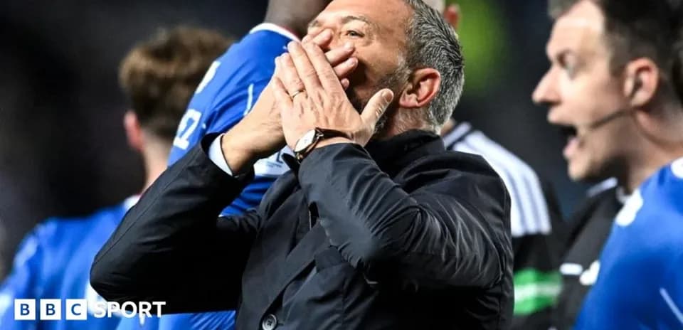 Manager reacting during match with players in background
