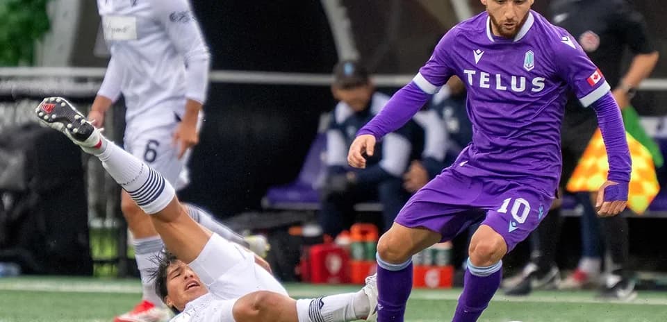 Player evading tackle during Vancouver FC match