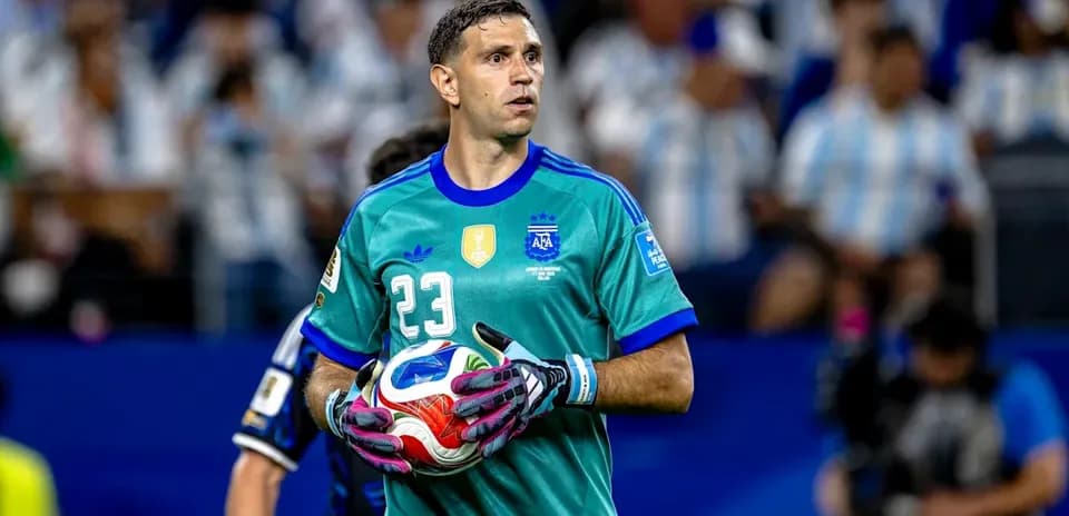 Goalkeeper in green uniform holding soccer ball
