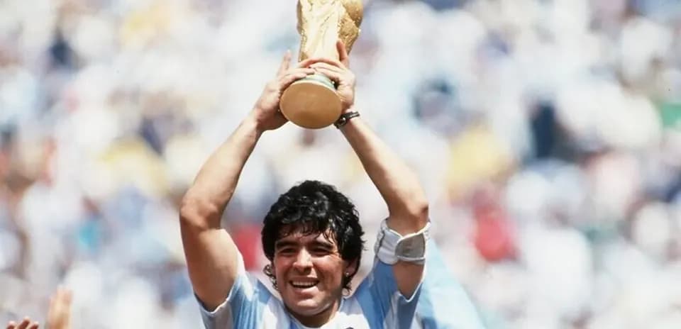 Player celebrating with World Cup trophy in stadium