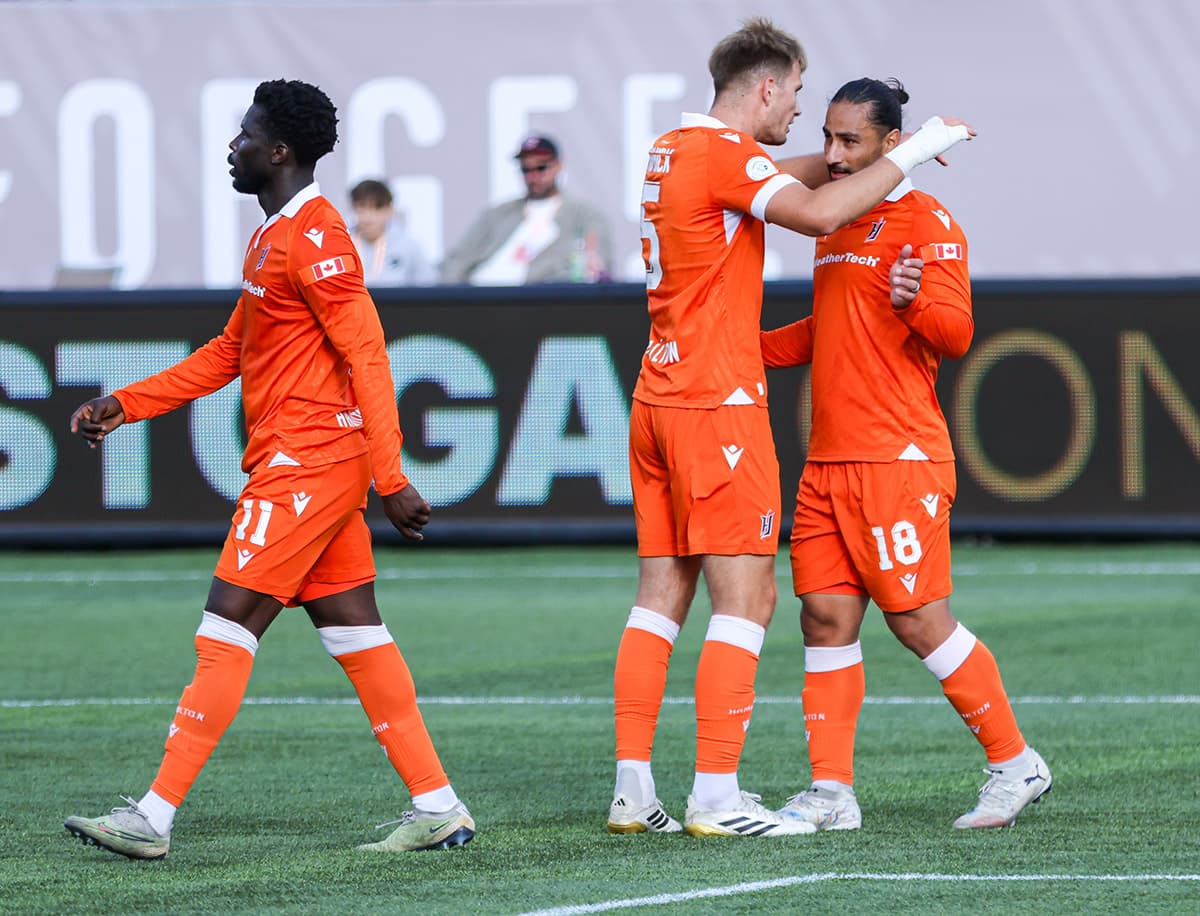 Players celebrating during Forge FC match