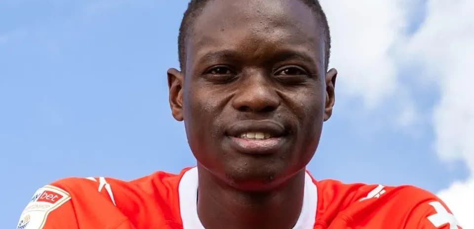 Player wearing red jersey against blue sky background