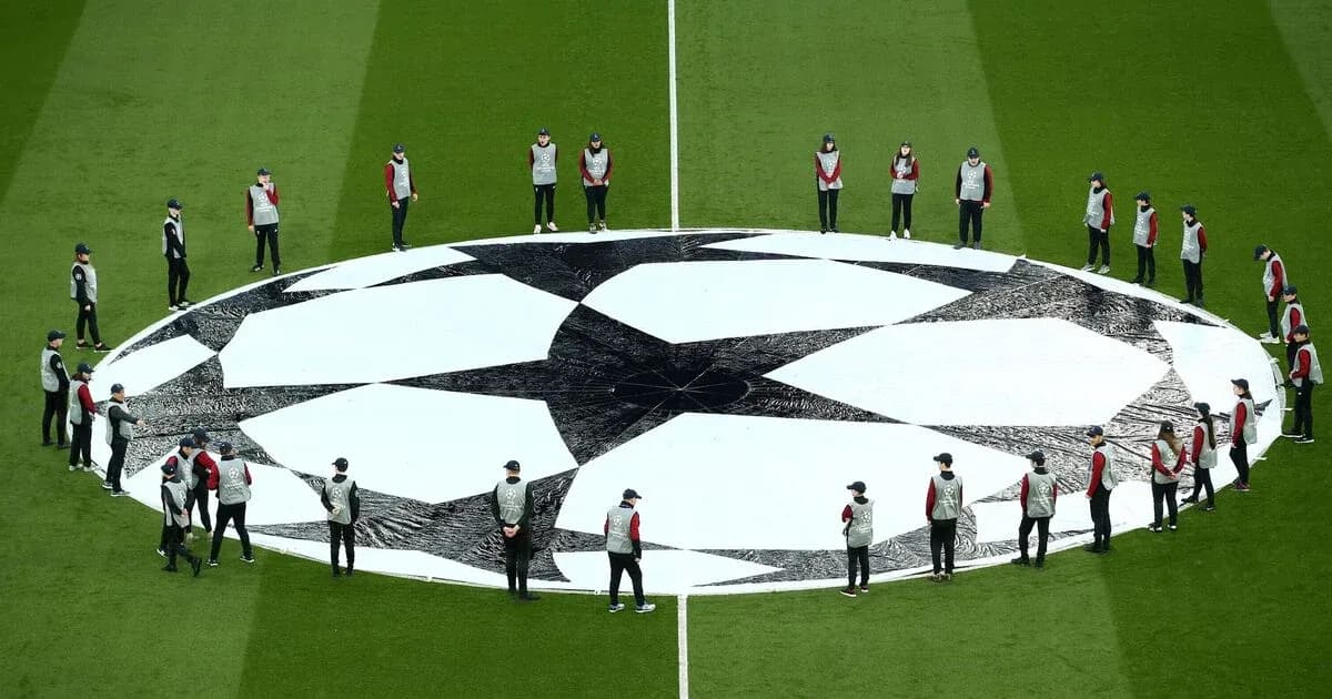 Ground staff preparing Champions League logo on field