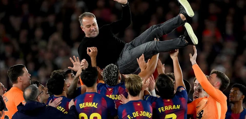 Barcelona players celebrating by lifting their coach