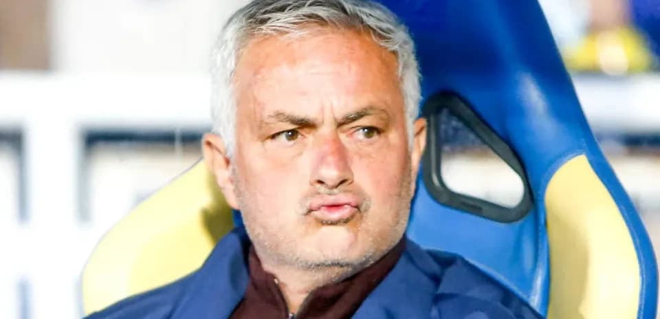Football manager seated on the bench during a match