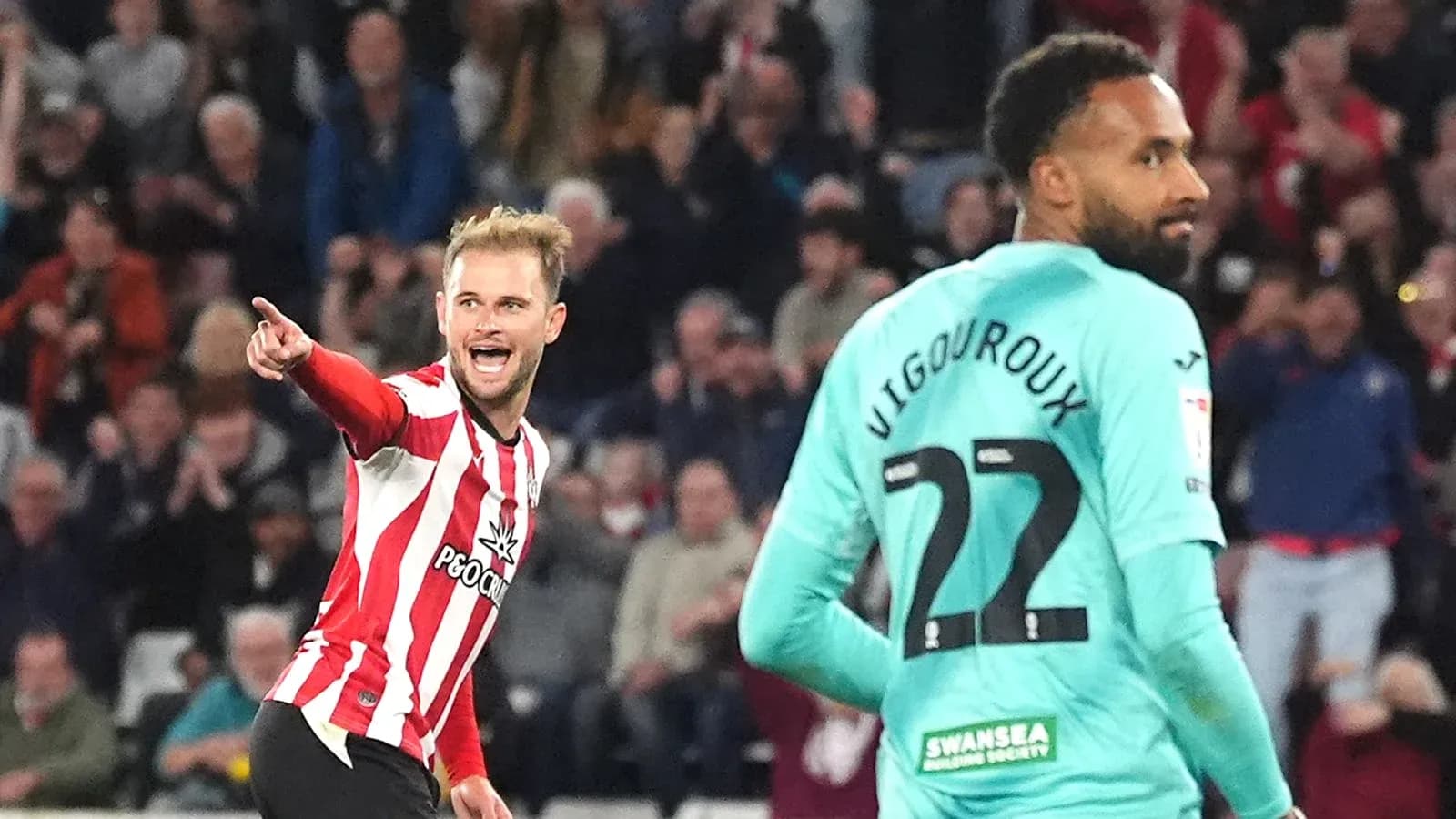 Player celebrating a goal against goalkeeper during match