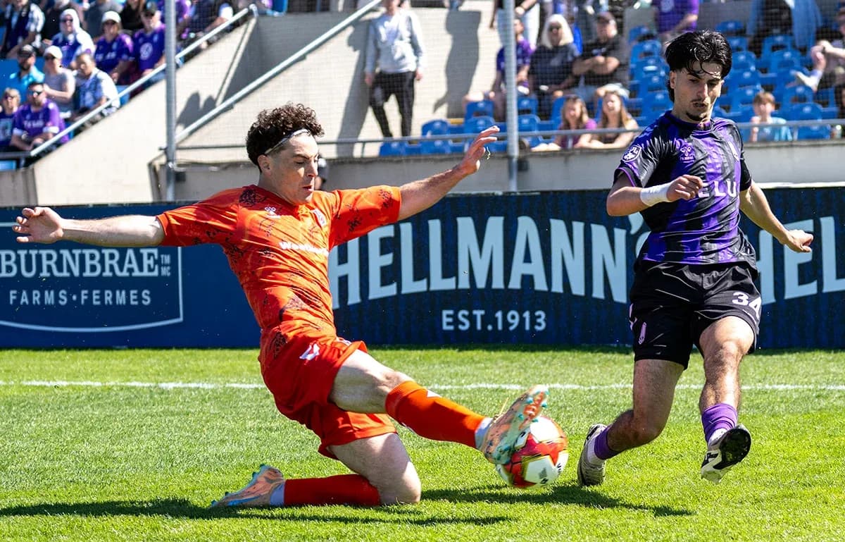 Player sliding tackle during Forge vs Pacific FC match
