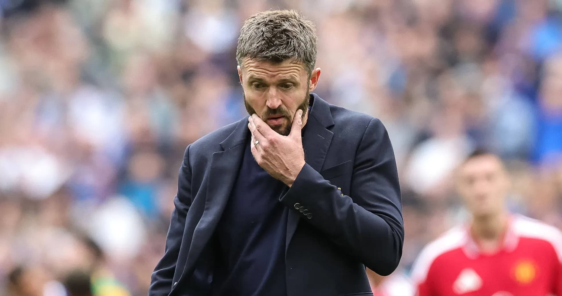 Coach looking pensive on the sidelines during match