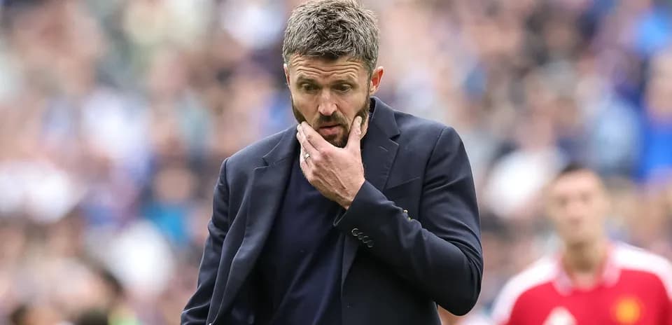 Coach looking pensive on the sidelines during match