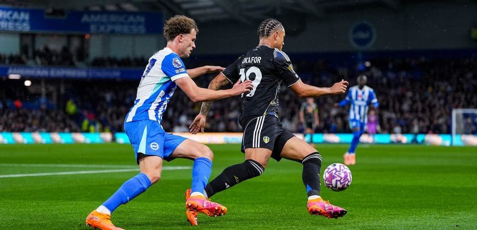 Leeds player dribbling past Brighton defender