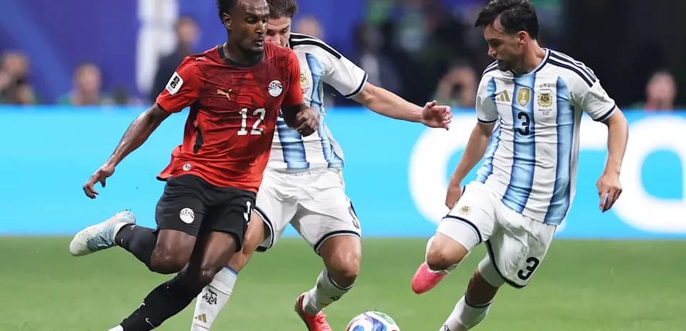 Egyptian player dribbling past Argentine defenders