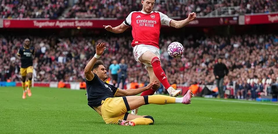Arsenal player avoiding tackle during match