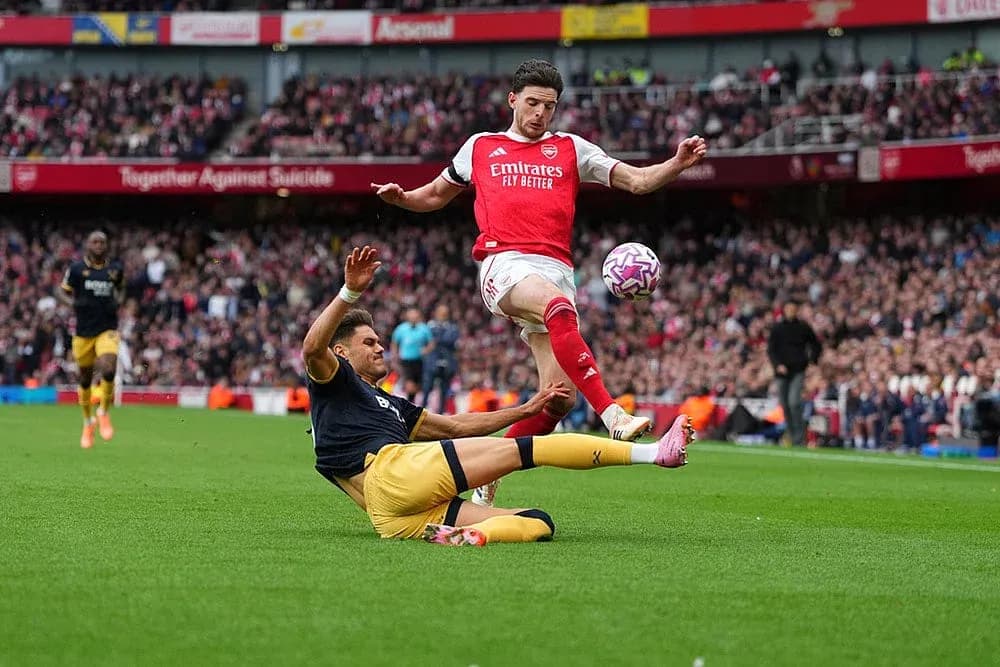 Arsenal player avoiding tackle during match