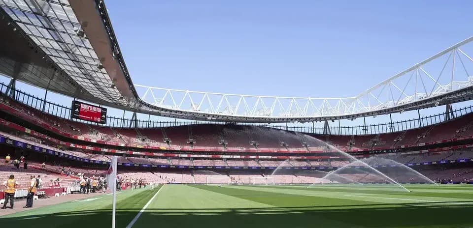 Empty stadium with sprinklers on the pitch