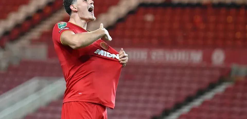 Player celebrating by lifting shirt after scoring goal
