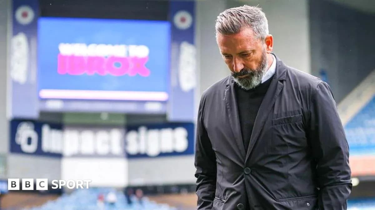 Coach walking on pitch with head down