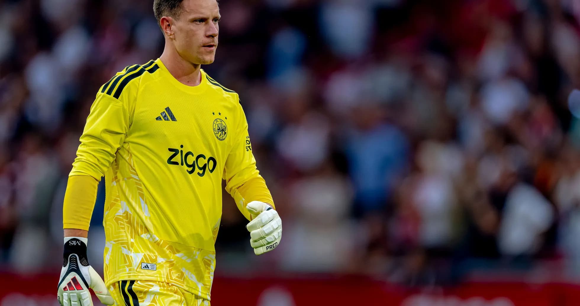 Goalkeeper in yellow kit walking on the field