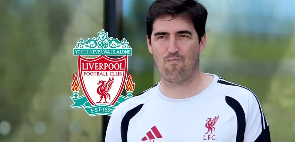 Man in Liverpool FC training gear near club logo