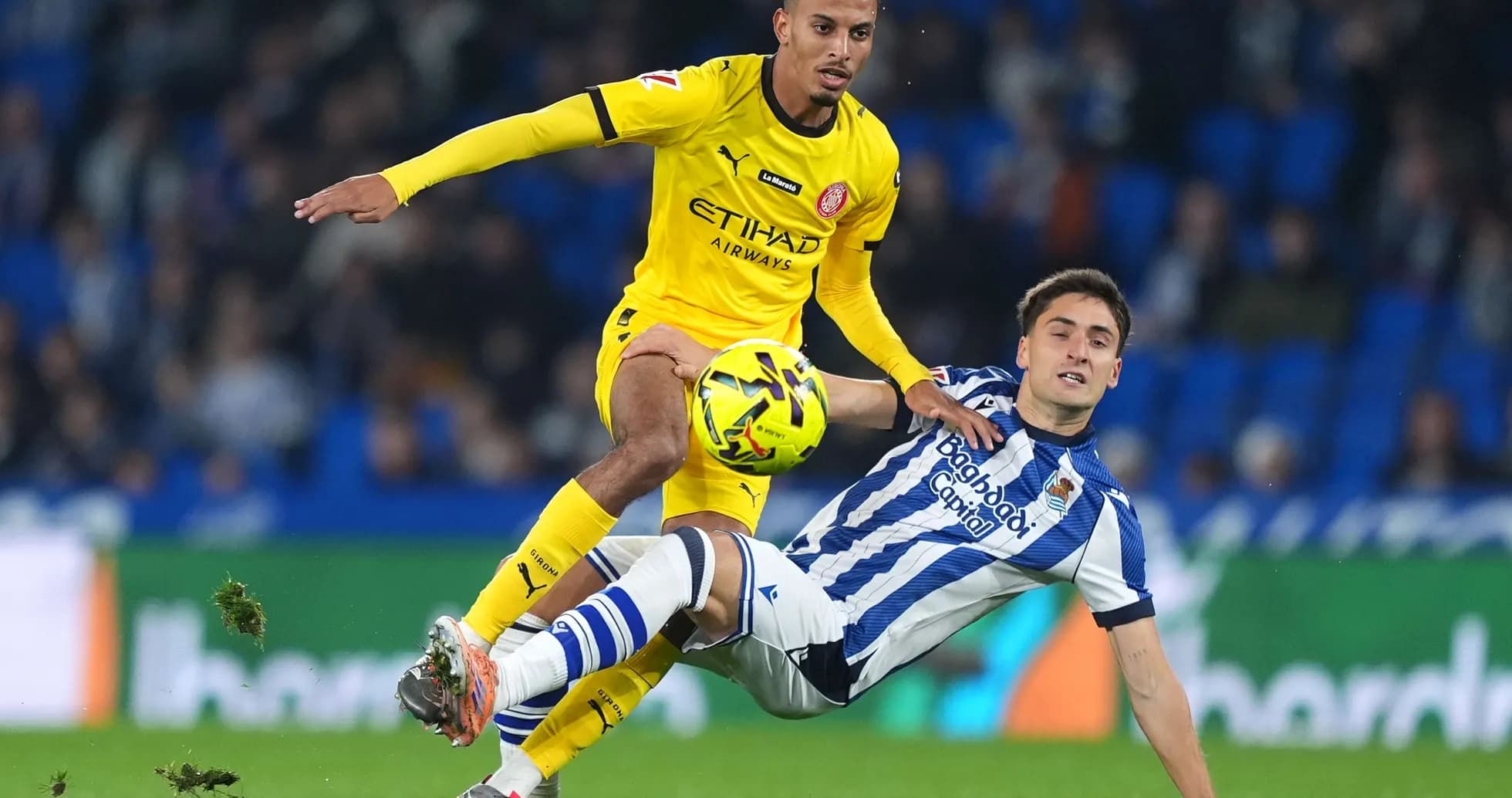 Girona player evading Real Sociedad tackle