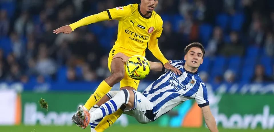 Girona player evading Real Sociedad tackle