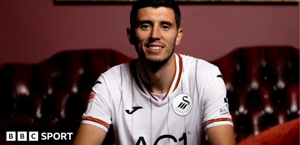 Player in Swansea City jersey sitting on couch